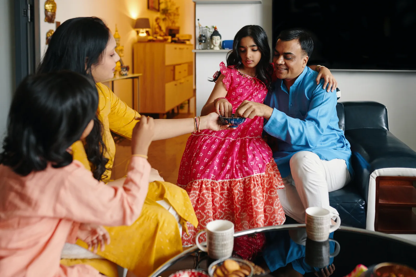 An Indian family sharing food together in their living room